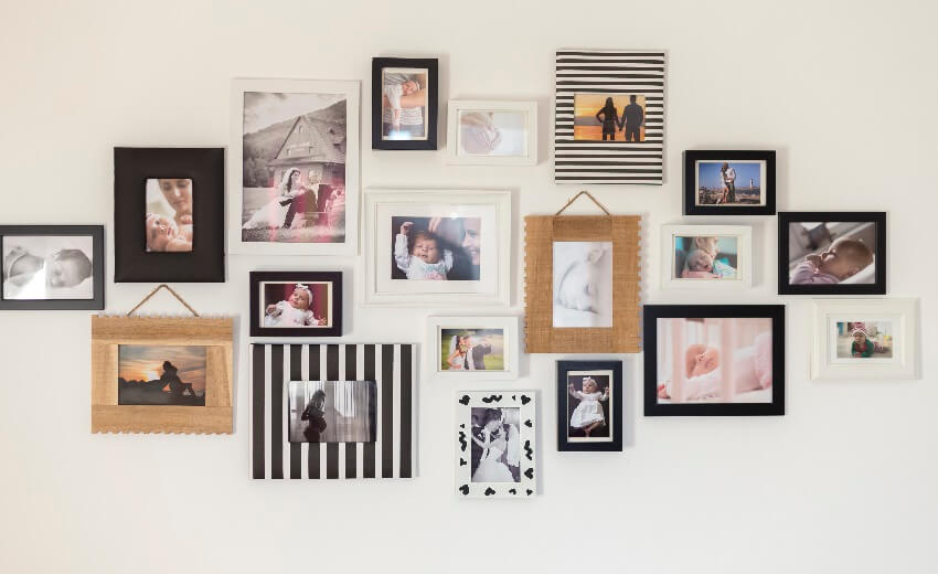 White wall with photos of a family in various picture frames