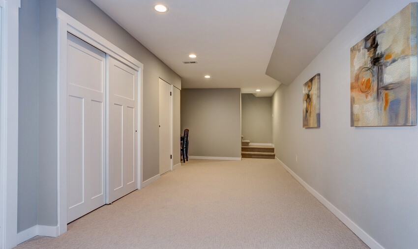 Wide hallway of home basement with paintings 