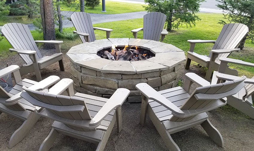 Backyard fire pit with wooden chairs