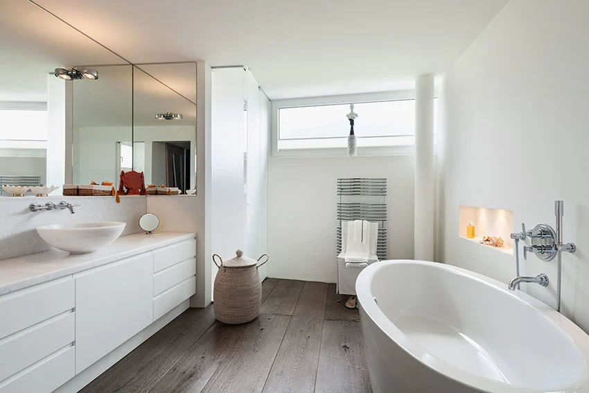 Bathroom with freestanding tub white vanity vessel sink laundry basket