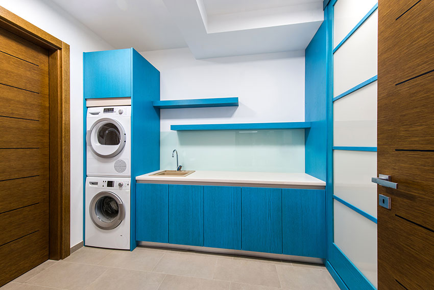 Laundry room with stacked washers blue cabinets