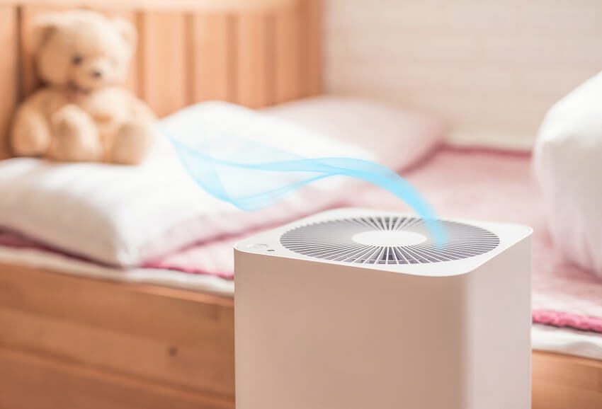 Air purifier in bedroom with wood bed