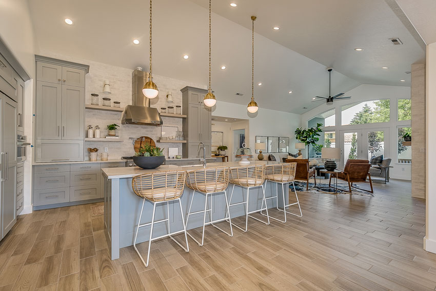 Airbnb rental with kitchen center island, high chairs, pendant, lights, and wood flooring