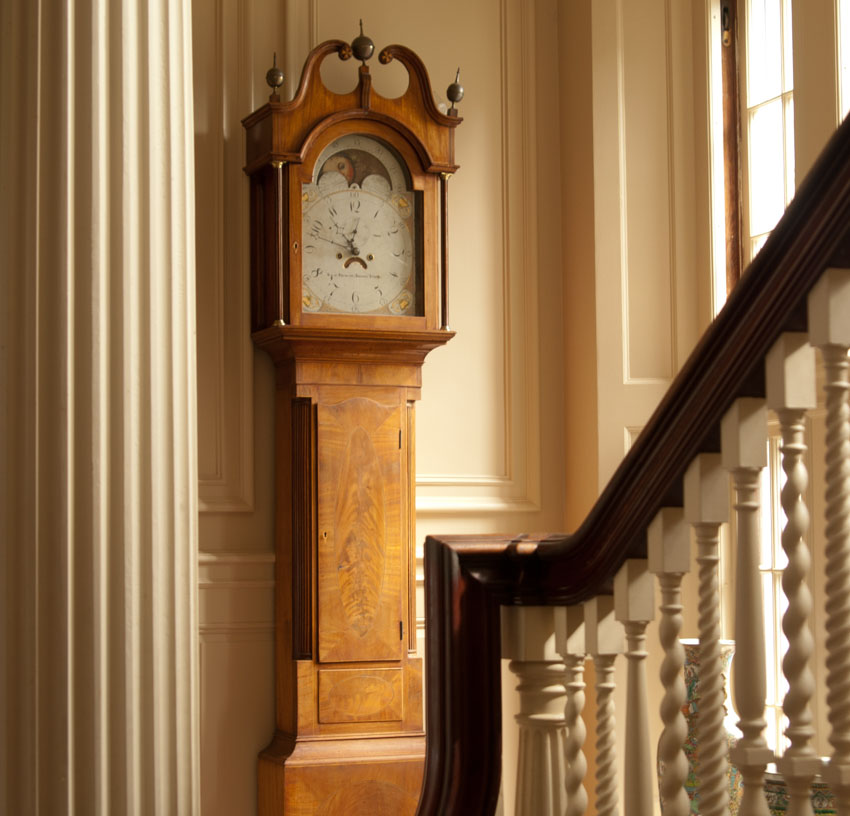 Antique clock near stairwall and window