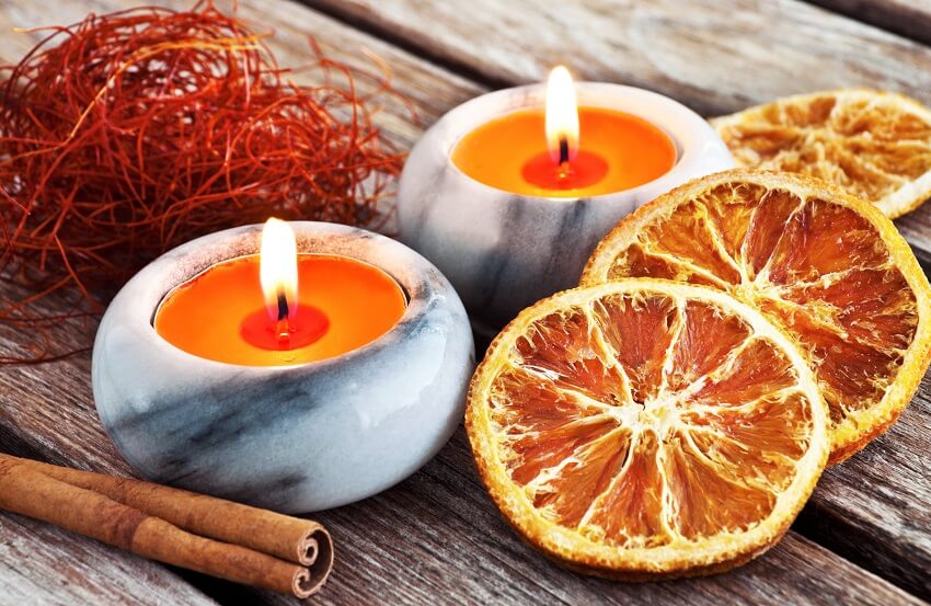 Autumn decorations with cinnamon stick and candles in marble with citrus scent