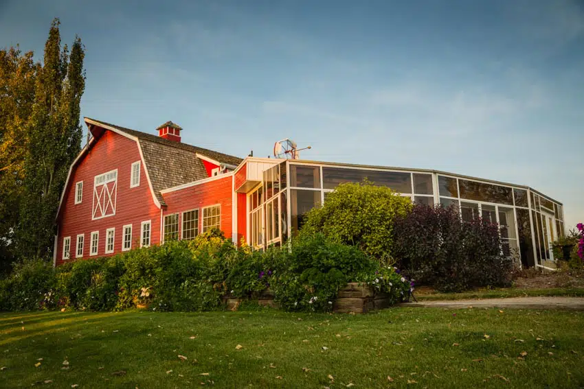 Barndominium with white windows, sunroom, and cupola