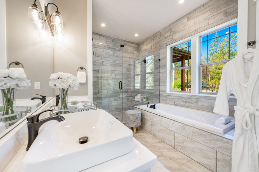Bathroom with fiberglass, tub, mirror, sink, windows, and recessed lights