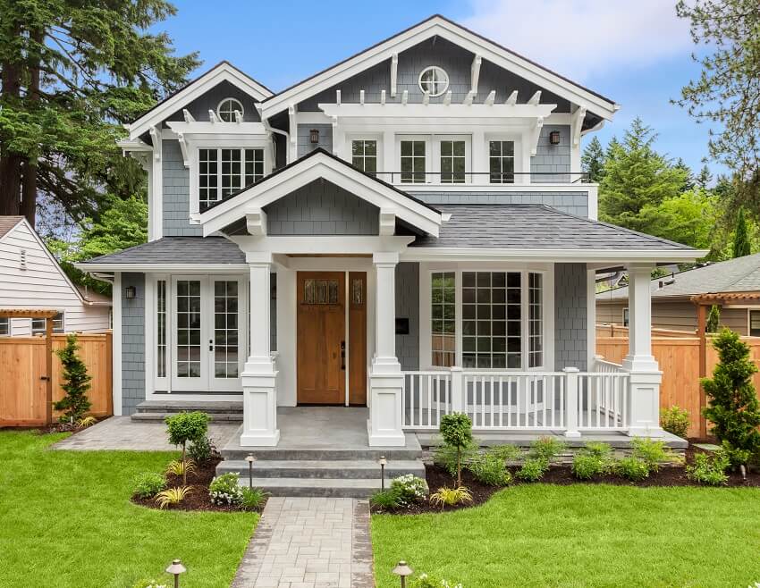 Beautiful grey and white home exterior with gable style porch and landscaped yard
