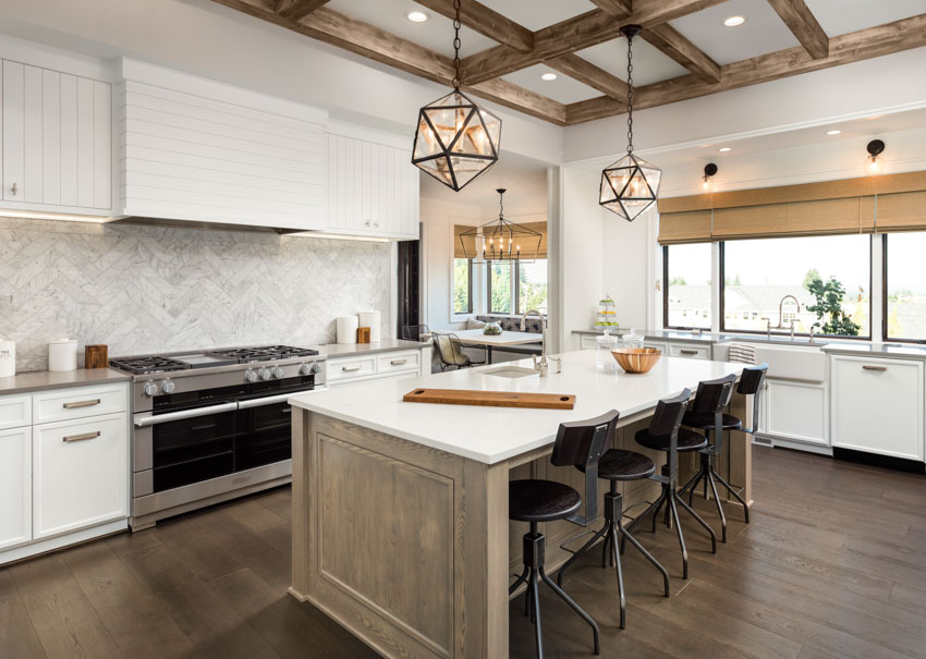Beautiful kitchen with glassos countertop, center island, pendant light, wood floor, range hood, stove, tile backsplash, and exposed ceiling beam