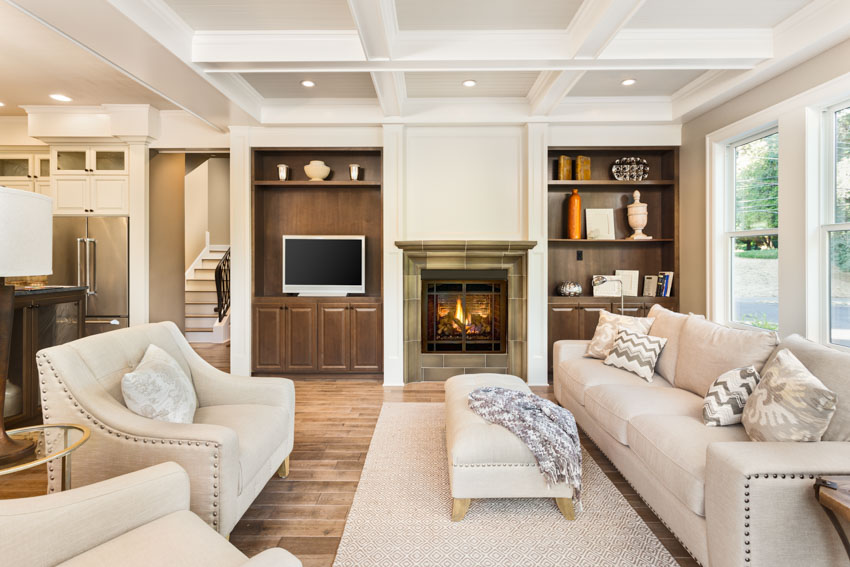 Beautiful living room with fireplace tile design, wood flooring, couches, recessed lights, and windows