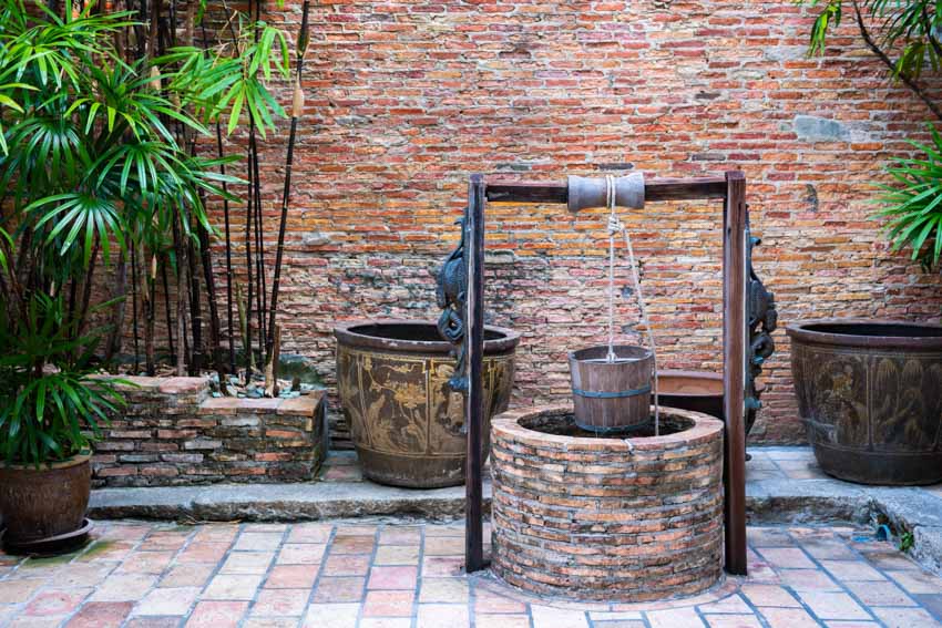 Brick well in an outdoor area with plants