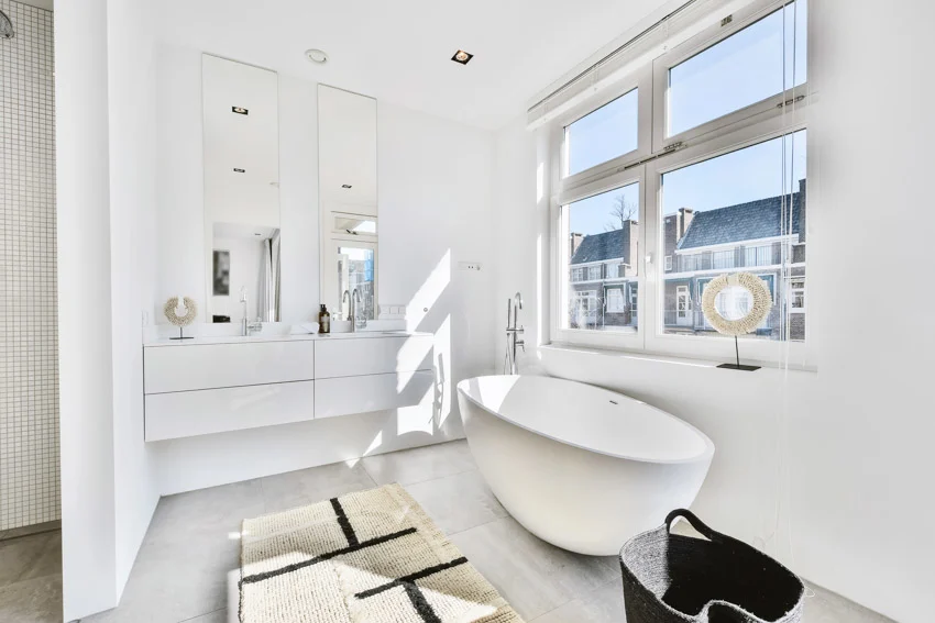 Bright and beautiful bathroom with tub, windows, mirror, and ceiling lights