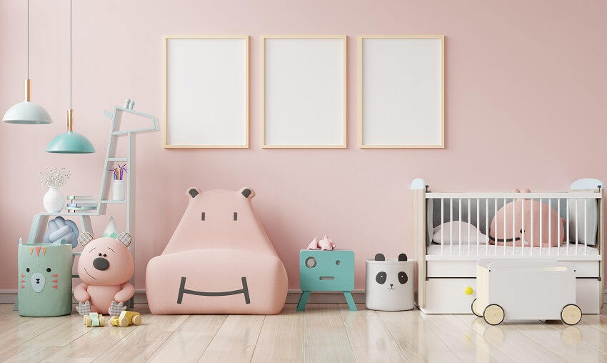 Child's room with pendant lights, wood floor, and empty poster frames on pink wall