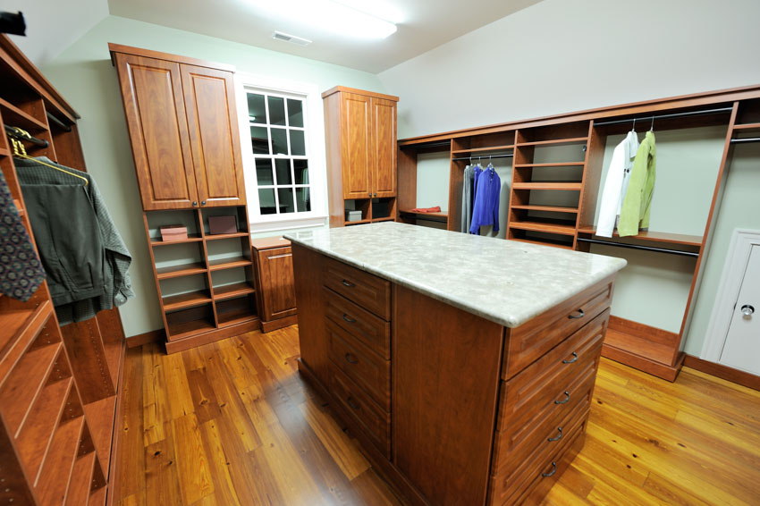 Closet with center island, countertop, and wood flooring