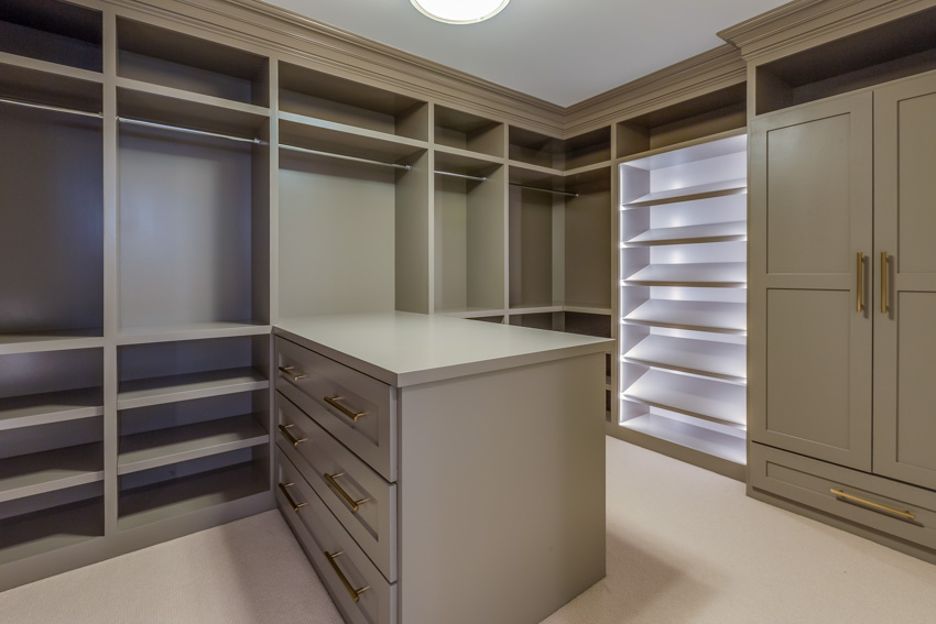 Closet with center island, countertop, empty cabinets, and drawers