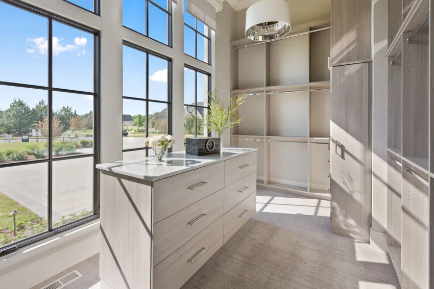 Airy closet with windows on one side and wooden shelves
