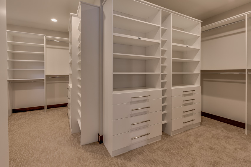 Closet with large cabinets, drawers, and ceiling lights