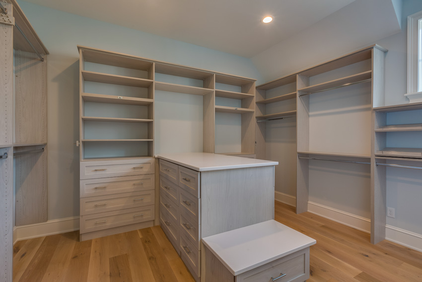 Closet with wooden flooring, center island, and ceiling lighting fixtures