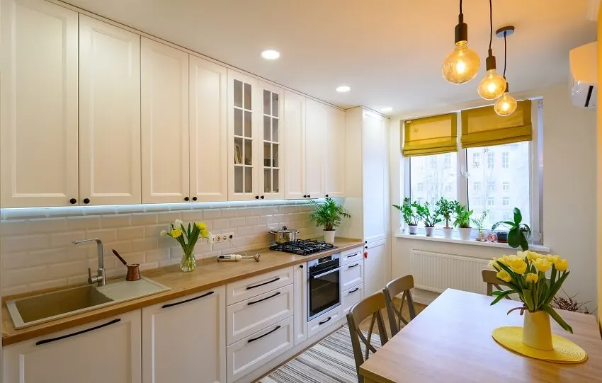 Cozy kitchen with wood dining table, brick backsplash, and curtain shades