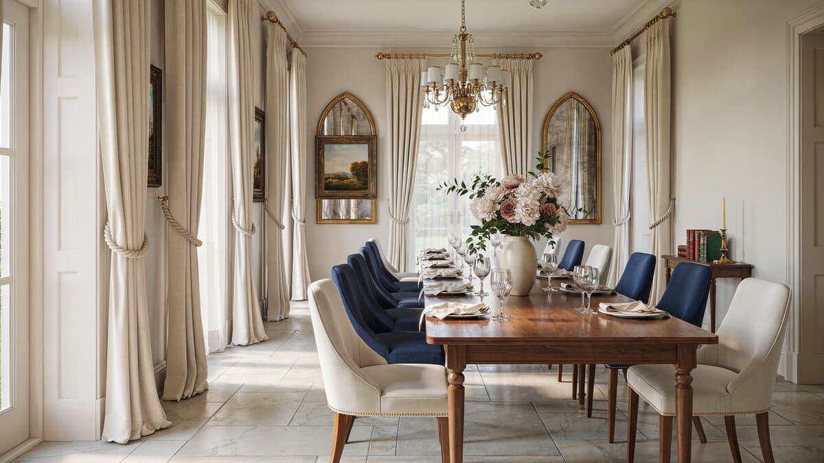 Long wood table lined with blue and cream chairs beneath a crystal chandelier