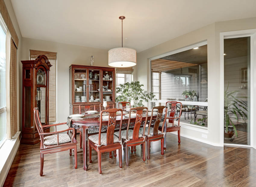 Dining room with grandfather clock, table, chairs, pendant light, and wood floor