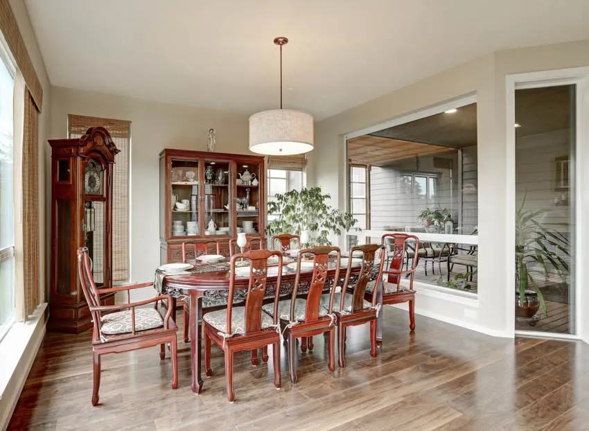 Dining room with clock, table, chairs, pendant light, and wood floor