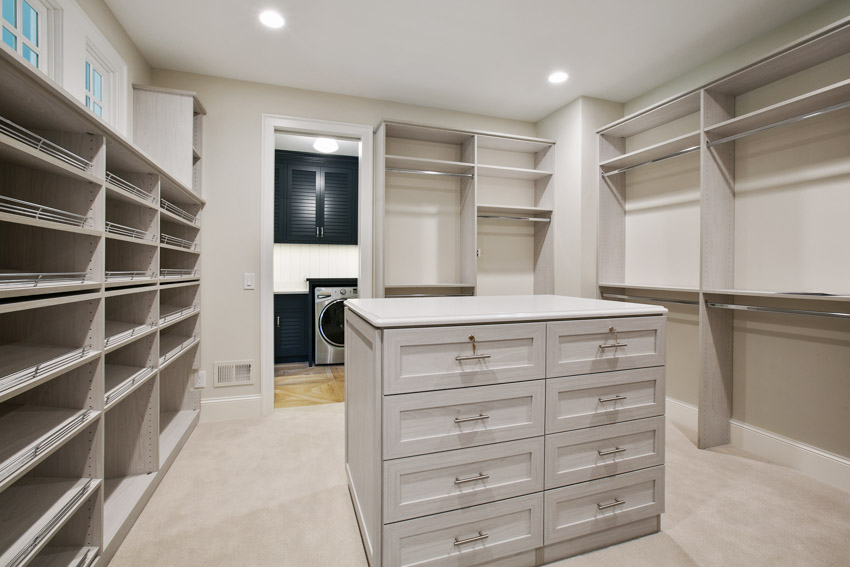 Empty closet with center island, open cabinets, and drawers
