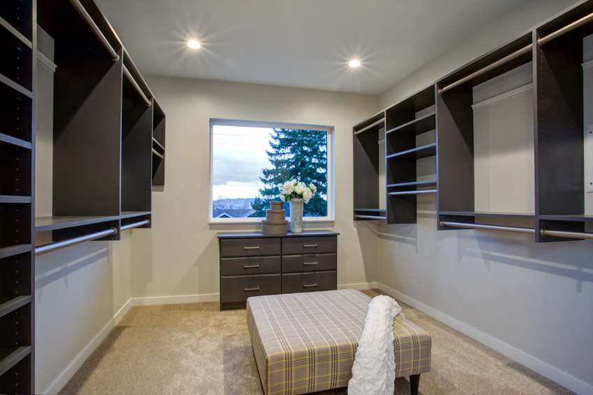 Closet with a picture window and ottoman