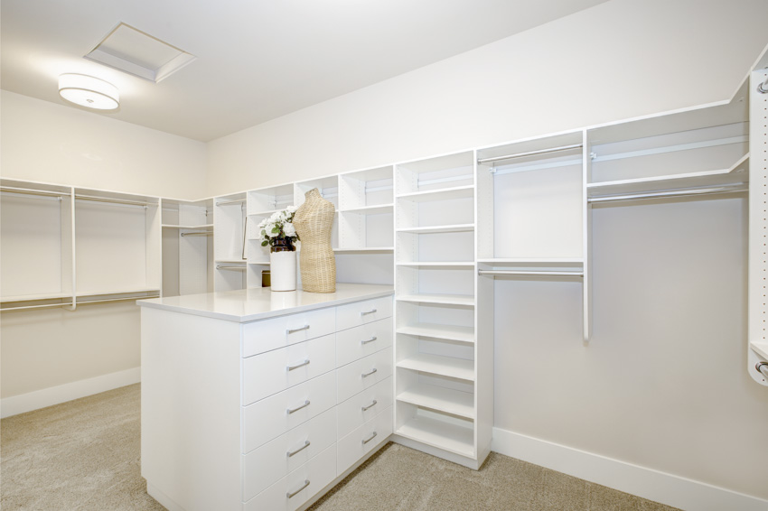 Empty closet with white center island and drawers