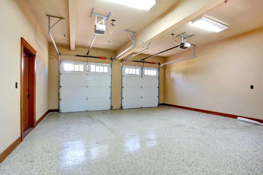 Empty garage with door openers, ceiling lights, and sealed floor