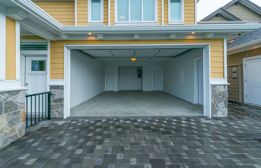 Empty garage with driveway, door opener, and finished flooring