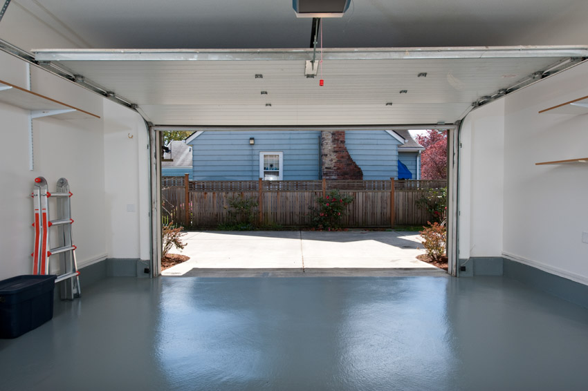 Empty garage with ladder, black box and door opener