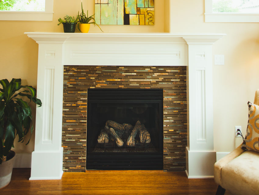 Fireplace featuring glass tile with wood flooring