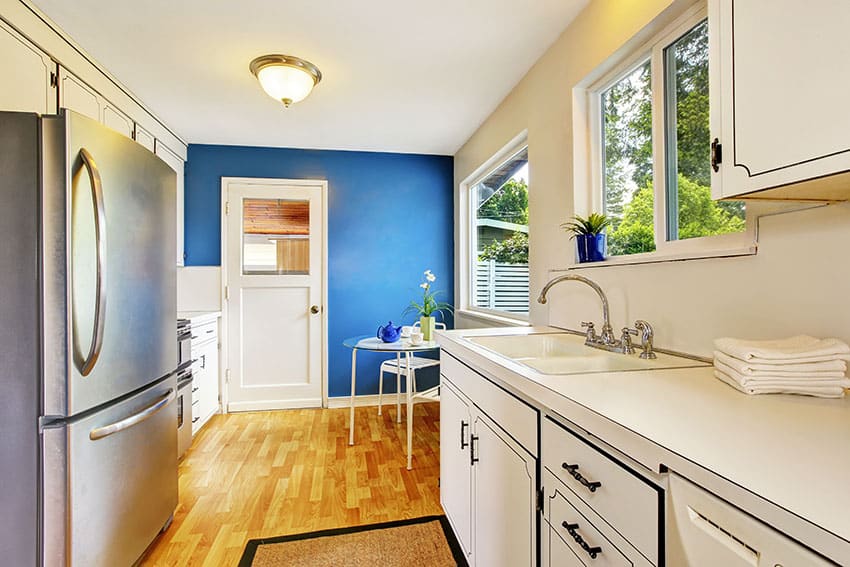 Galley kitchen with blue painted accent wall