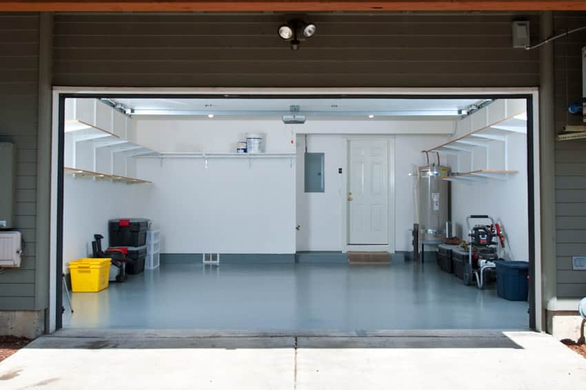 Garage with water heater, sealed floor, and ceiling lights