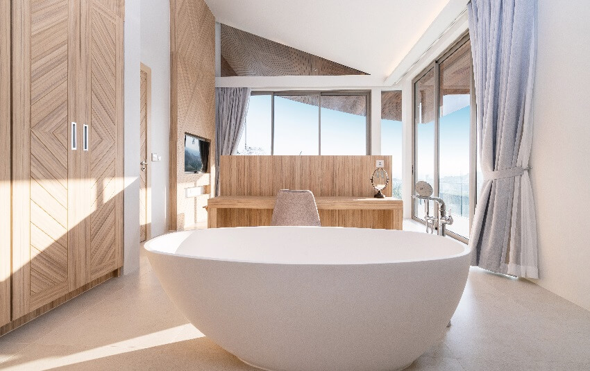 Garden tub in a modern villa bathroom with wood cabinets and tile floor