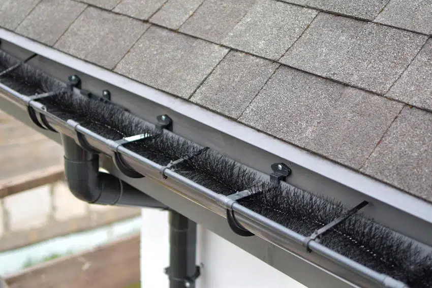 Gutter with brush type of guard