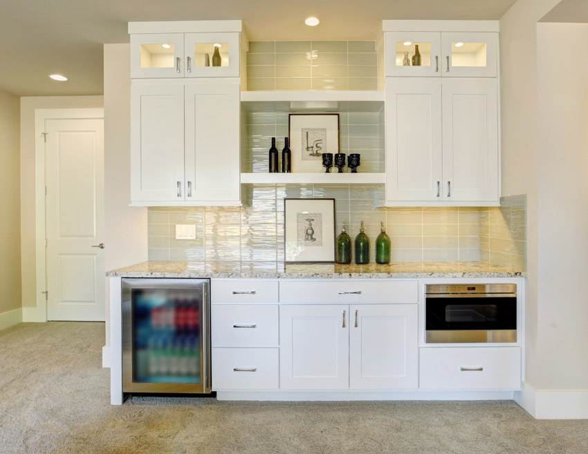 Home bar with wet backsplash, beverage cooler, white cabinets, and countertop