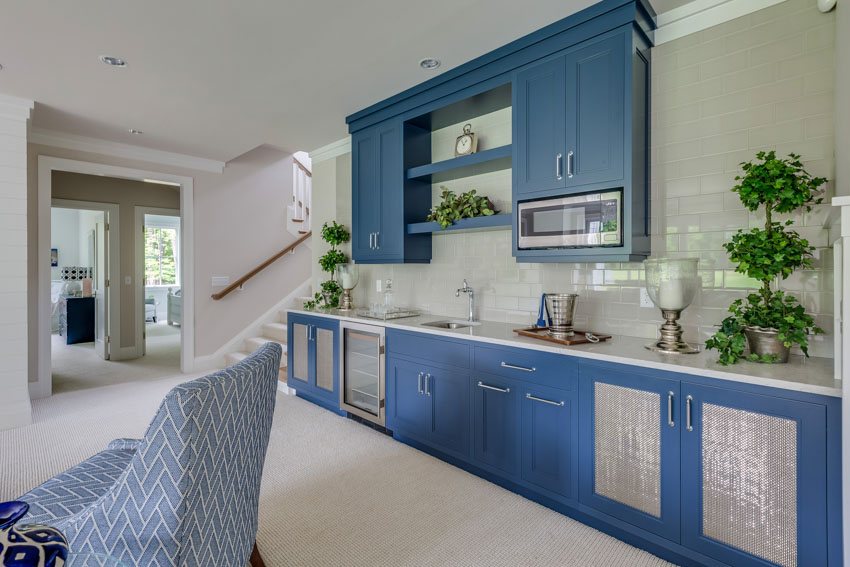 Home wet bar with backsplash, blue cabinets, countertop, and wine cooler