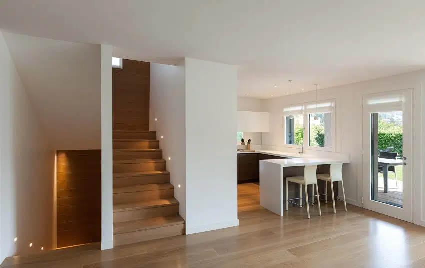 Kitchen with white walls, breakfast bar with chairs and glass wall