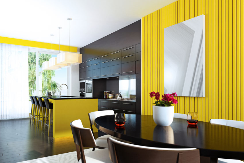 Kitchen and dining space with yellow slat accent wall, center island, and pendant lights