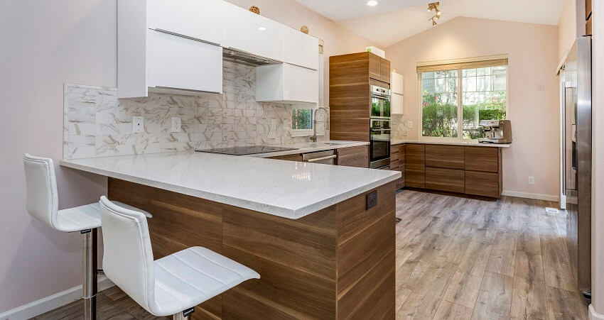Kitchen room with quartz countertops, wooden cabinets, marble tile backsplash, and modern laminate floor