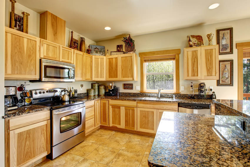 Kitchen with agate countertop, wood cabinets, oven, and window