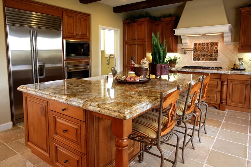 Kitchen with center island, sealed granite countertop, tile flooring, and chairs