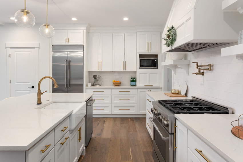 Kitchen with center island, wood floor, white countertop, pendant lights, cabinets, and wood flooring