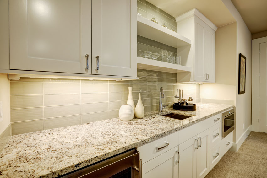 Kitchen with countertop, wet bar backsplash, and white cabinets