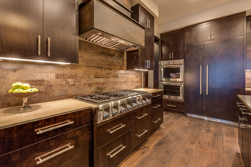 Kitchen with dark wood cabinets wood look tile backsplash behind stove