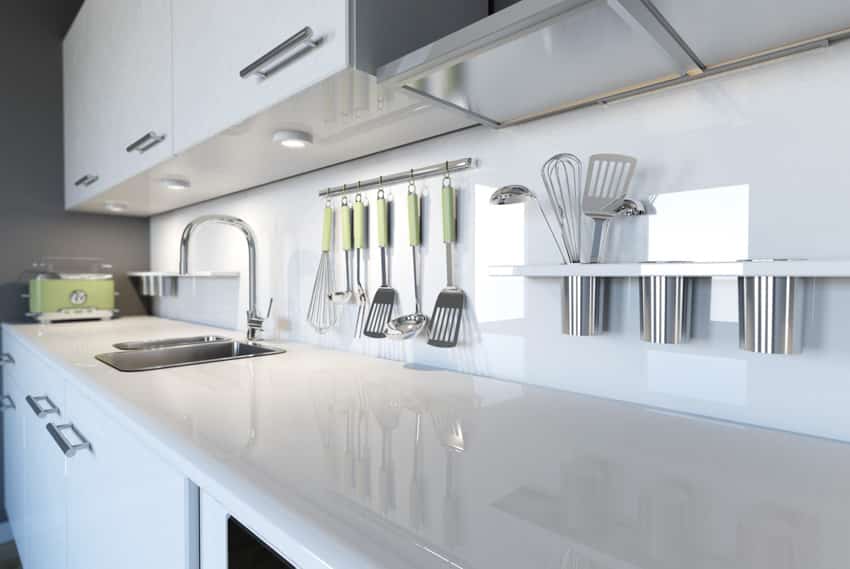 Kitchen with white backsplash, sink and under cabinet lighting
