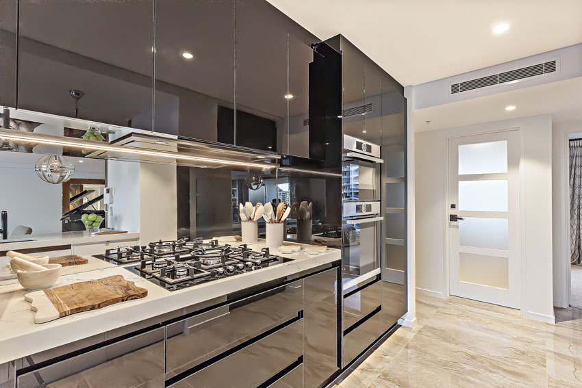 Kitchen with glossy acrylic cabinets, stove, countertop, and wood floor