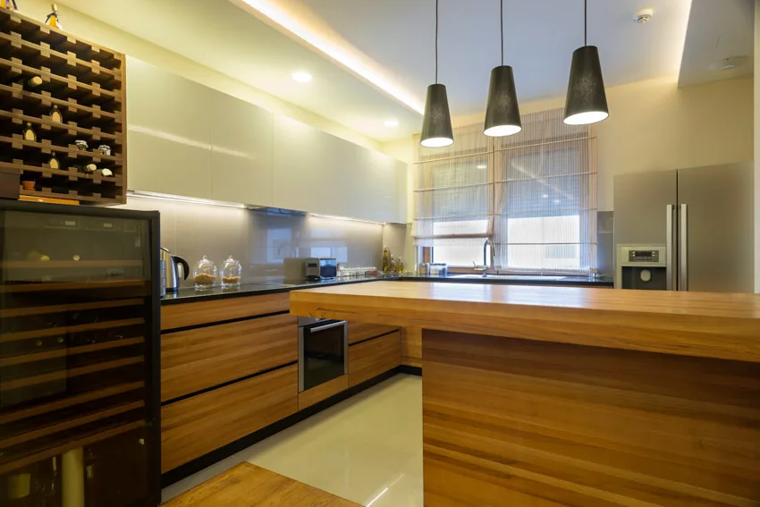 Kitchen with wet bar, glass backsplash, pendant lights, wine cooler, and wood cabinets